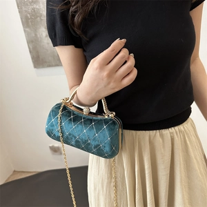 Close-up of dark green velvet handbag with quilted crystals and vintage gold clasp