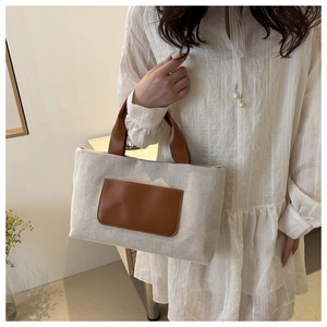 Detail of canvas tote bag with brown leather pocket and handles for daily use