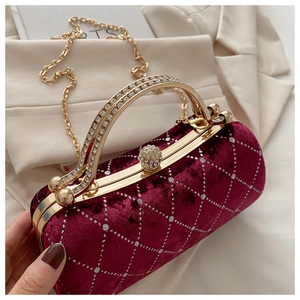 Detail of burgundy velvet clutch with crystal handle and metallic chain strap