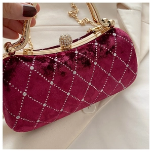 Close-up of burgundy velvet clutch with diamond lattice pattern and gold rhinestone clasp