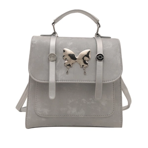 Stylish grey butterfly backpack for women featuring polished silver metal accents and top handle