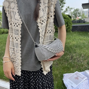 Sparkling silver rhinestone bucket bag with chain strap shown in an outdoor setting