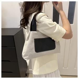 Detail shot of canvas tote bag with black leather pocket shown in lifestyle setting