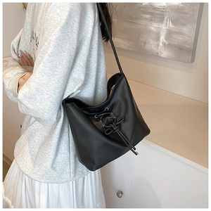 Detail shot of a black PU leather bucket bag featuring a unique drawstring knot design