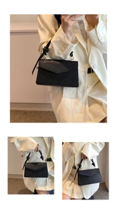 Detail of black pebbled leather crossbody bag with knotted rope handle and gold metal rings