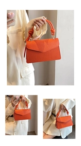 Detailed macro view of orange litchi grain faux leather handbag with knot handle design