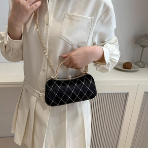 Elegant black velvet handbag with gold hardware and chain strap shown in a lifestyle setting