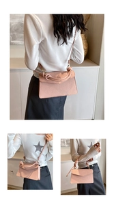 Detailed view of pink pebble grain handbag with knotted handle and gold metal hardware
