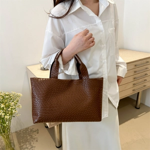 Brown woven lattice tote bag with dual handles shown in a lifestyle scene for daily use