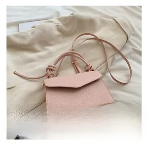 Detailed close-up of pink lychee pattern leather handbag with knotted handle detail