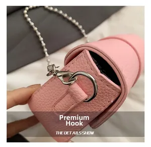 Gros plan du fermoir en argent de qualité et de la chaîne à billes sur sac rose