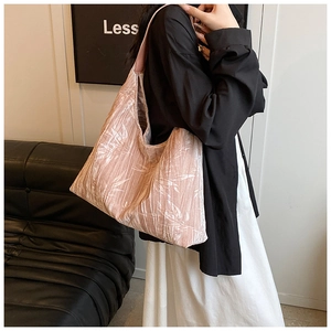 Detail of light pink pleated tote bag featuring white bamboo leaf print on soft fabric