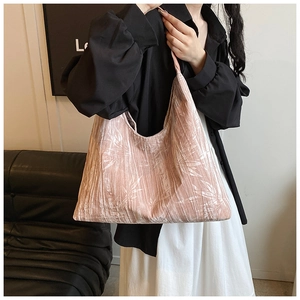 Detail of pink pleated tote bag featuring white bamboo leaf patterns and soft texture