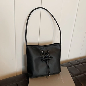 Black ballet-style bucket bag with lace-up details and silver metal eyelets