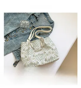 Detail of elegant jacquard bag with bamboo handle, pearl chain, and wave patterns