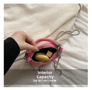 Intérieur du sac selle rose montrant la texture du cuir et la bandoulière chaîne argent