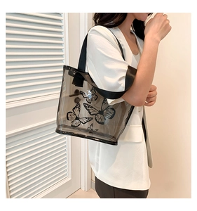 Detail showing transparent smoky grey PVC tote with black butterfly print and wide strap