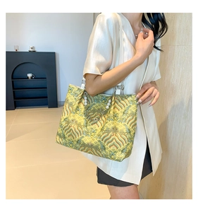 Detail view of tote bag with traditional Chinese wave embroidery and pearl charm strap