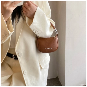 Détail du mini sac en cuir grainé marron avec rivets étoiles argentés et boucle en métal