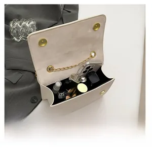 Detail view of the white flap bag interior showing capacity for phone and lipstick