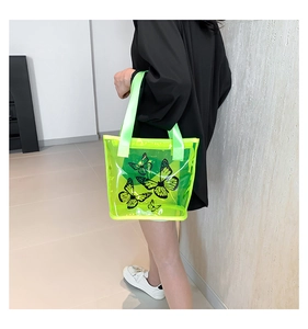 Close-up of neon green transparent PVC tote bag featuring black butterfly prints