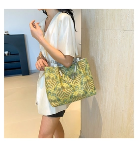 Detail of traditional wave pattern tote bag with pearl pendant and white leather straps