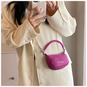 Detailed view of mini purple crossbody bag with silver star accents on white blazer