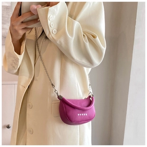 Detailed view of fuchsia leather mini saddle bag with silver star motifs and chain strap