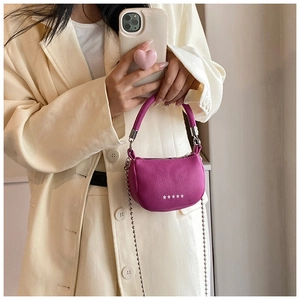 Détail macro du mini sac selle en cuir magenta avec étoiles argentées et chaîne