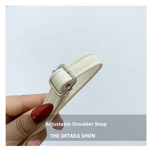 Detail of adjustable white faux leather shoulder strap with silver buckle and stitching