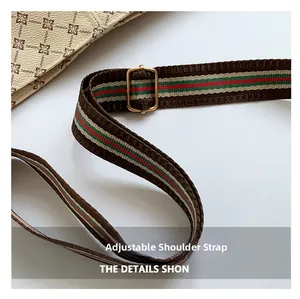Close-up of adjustable woven shoulder strap with green and red stripes and gold hardware