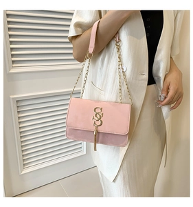 Detailed view of pink matte shoulder bag with gold double S hardware and long tassel