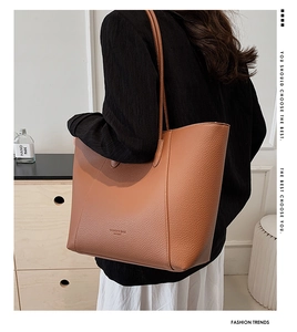 Gros plan d'un sac cabas en cuir grainé marron caramel avec logo sur le mannequin