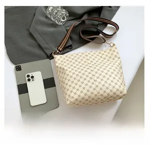 Flat lay of cream tote bag with geometric patterns and red-green striped fabric strap
