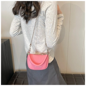 Vue arrière d'un mannequin portant un sac besace en cuir rose avec rivets étoilés