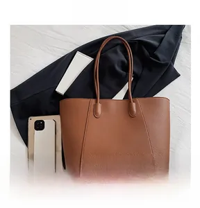 Vue détaillée du grand sac cabas en cuir marron avec tablette pour comparer la taille