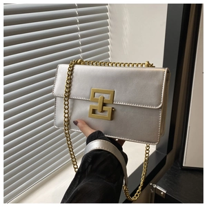 Détail du sac à chaîne argenté avec fermoir géométrique doré et texture métallique