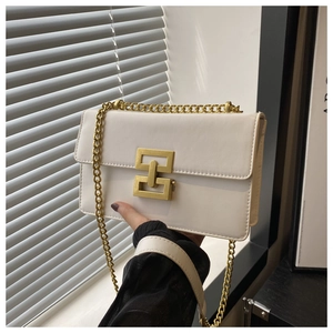 Détail du sac à rabat blanc avec boucle dorée géométrique et texture en cuir lisse