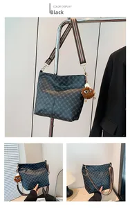 Detail of black vintage bucket bag featuring geometric patterns and a plush doll charm