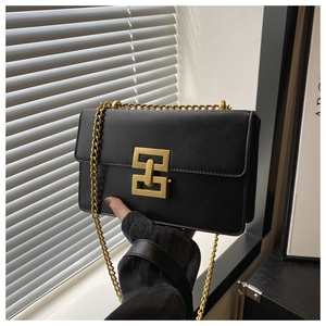 Détail du sac bandoulière noir élégant avec fermoir géométrique doré et bandoulière chaîne