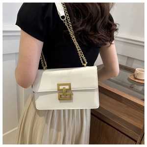 Back view of model wearing a white leather crossbody bag with gold chain strap