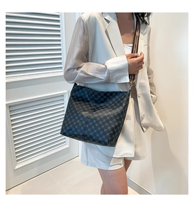 Detail of crossbody bag with geometric pattern and striped fabric shoulder strap