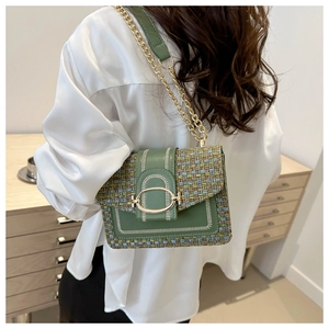 Détail du sac bandoulière en tweed vert avec boucle dorée sur chemisier satin