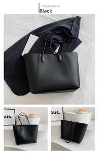 Détail du sac cabas en cuir grainé noir avec des fines bandoulières minimalistes