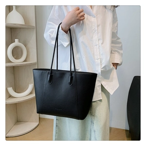 Détail du cabas noir minimaliste en cuir grainé avec des coutures élégantes