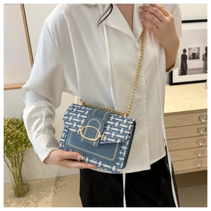 Détail du sac bandoulière en tweed bleu et blanc avec boucle dorée et bandoulière chaîne