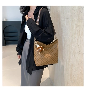 Detail of vintage brown tote bag featuring star pattern and striped wide shoulder strap