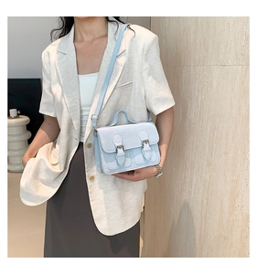 Detail of light blue Cambridge style handbag with buckle straps and smooth leather texture