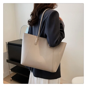 Détail du sac cabas en cuir beige souple avec texture grainée et lettrage embossé