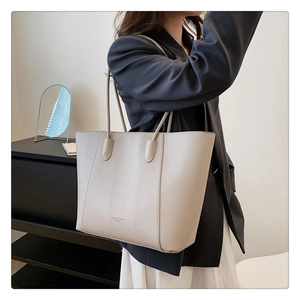 Détail du sac cabas en cuir à motif litchi avec texte Fashion et bandoulière souple